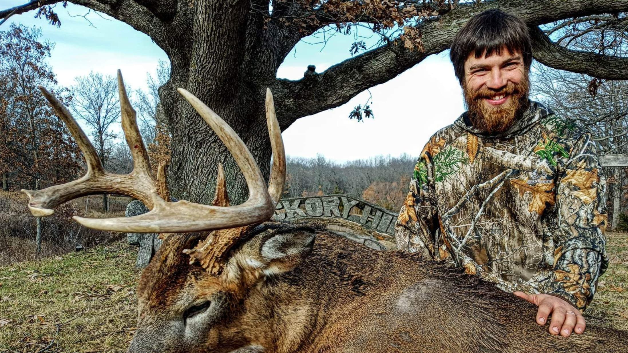 Hunter smiles with large antlers of a deer he harvested.